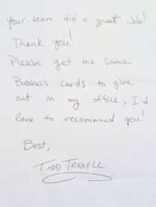 Handwritten note from a satisfied customer praising the team’s work and requesting business cards to recommend their services. Signed "Todd Troxell."
